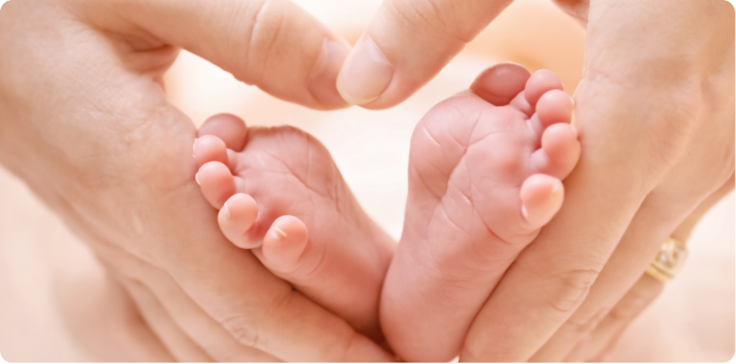 Parents gently holding a baby's feet